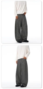 Détail du pantalon large à rayures verticales noires et blanches au tissu fluide et élégant