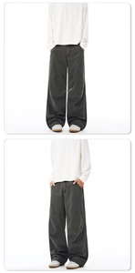 Detailed close-up showing dark grey wide-leg cotton pants with pleated panel stitching