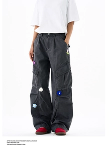Détail de la broderie fleurie colorée sur le pantalon cargo gris anthracite avec poches