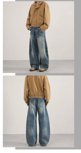 Détail d'une veste de travail kaki et d'un jean baggy bleu clair avec moustaches délavées