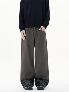 Dunkelgraue weite Stoffhose im minimalistischen Cleanfit-Stil für Herren am Model