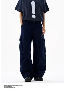 Detail of dark blue wide-leg cargo pants with large side pockets and thick cotton canvas