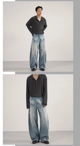 Detail view of vintage washed curved seam jeans and grey henley shirt on a male model