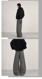 Rear view of oversized black hoodie paired with vertical striped wide-leg casual pants