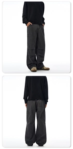 Detail view of charcoal grey cargo pants featuring functional side flap pockets