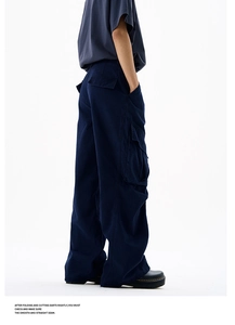 Detail view of navy cargo pants showing side flap pockets and twill cotton texture