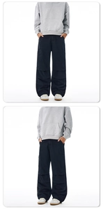 Detail view of urban outdoor black wide-leg cargo pants with multi-pocket and patchwork design