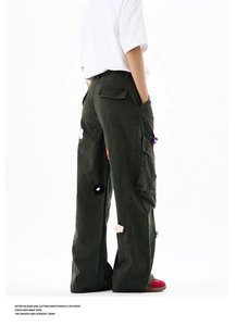 Détail du pantalon cargo avec écussons floraux brodés et grandes poches à rabat