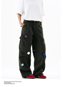 Vue détaillée d'écussons floraux crochetés colorés sur un pantalon cargo vert taille haute