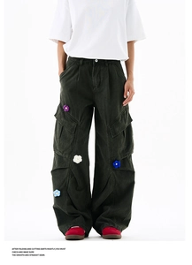 Vue détaillée des broderies de fleurs au crochet sur le pantalon cargo large vert foncé