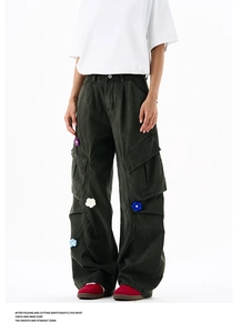 Détail de broderies florales 3D sur un pantalon cargo délavé foncé avec coupe large