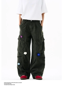 Détail de fleurs 3D brodées sur un pantalon cargo large en vert foncé