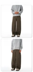 Detail der dunkelbraunen Lounge-Hose mit gebogenen Nähten und grauem Kapuzenpullover