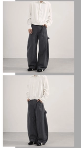Dettaglio di pantaloni cargo grigio scuro a gamba larga con cinturini laterali e cotone