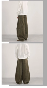 Detail shot of oversized olive green cargo pants with vintage paneling and curved seam design