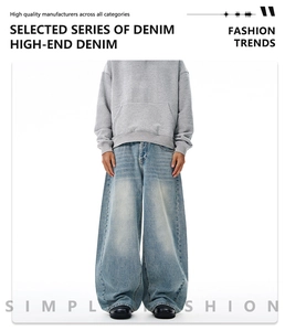 Close-up of light blue wide-leg denim jeans with retro washed texture and baggy fit