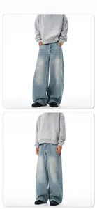 Detail of light blue washed denim jeans with a baggy cut and vintage distressed finish