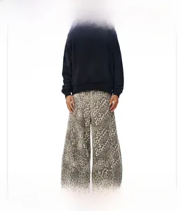 Dettaglio dei jeans a gamba larga con stampa leopardata e trama lavata retrò