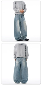 Detail view of baggy oversized denim pants with washed whiskering and stacked hem effect
