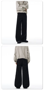 Detail view of black wide-leg cotton pants featuring a relaxed fit and heavy fabric texture