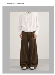 Detailed view of brown wide-leg trousers with contrast stitching and casual silhouette