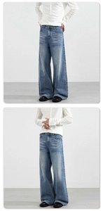 Gros plan d'un jean large bleu vintage avec délavage moustaches et détails usés