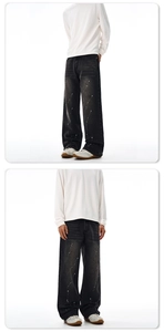 Detailed view of dark grey wide-leg jeans with artistic white ink splash patterns