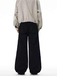Vue arrière d'un pantalon large noir taille haute associé à une chemise rayée à manches