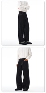 Detailansicht der schwarzen Wide-Leg-Jeans mit hoher Taille und gelben Kontrastnähten aus Denim