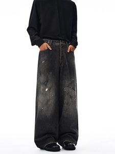 Men's baggy distressed jeans with paint splatter details and vintage wash finish