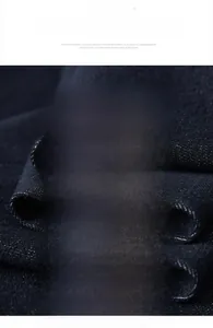 Dettaglio del tessuto denim blu scuro che mostra la trama a saia morbida e di qualità
