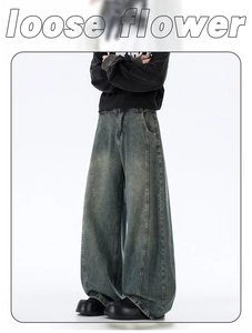 Close-up of loose wide-leg jeans in dark blue distressed vintage wash and street style