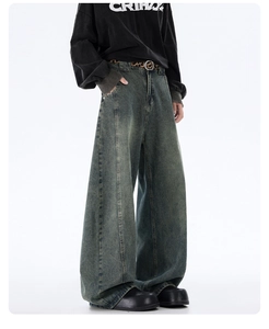 Detail view of washed baggy jeans with vintage distressed finish and leopard print belt