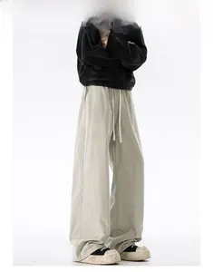 Detail view of khaki cotton oversize straight pants with drawstring elastic waistband