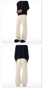 Dettaglio dei pantaloni a gamba larga bianco sporco con stile cleanfit e tessuto drappeggiato
