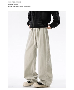 Close-up of beige wide-leg cotton pants featuring drawstring waist and premium stitching