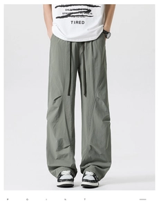 Close-up of olive green cargo pants featuring drawstring waist and seam details