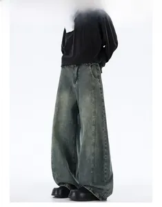 Detail view of baggy distressed denim jeans with vintage washed whiskers and wide-leg cut