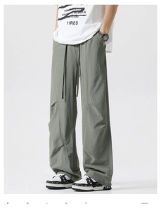 Detail of army green wide-leg cargo pants with drawstring waist and paneling design