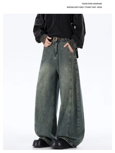 Detail view of vintage grey-blue loose wide-leg denim jeans with washed distressed texture