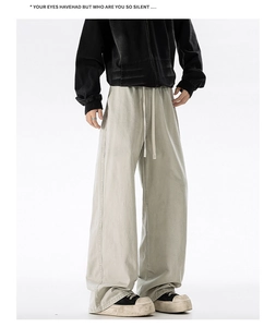 Detail of light khaki wide-leg cotton pants featuring a drawstring elastic waist and stitching