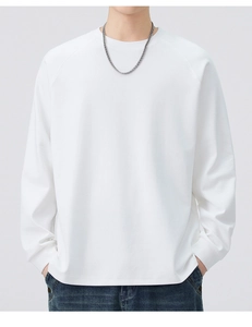 Detail of white crewneck sweatshirt with raglan sleeves and a silver Cuban chain necklace