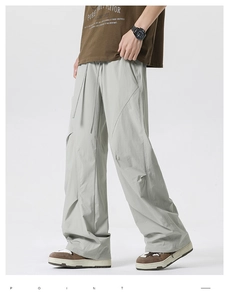 Detail of loose sage green paratrooper pants with elastic drawstring waist and stitching