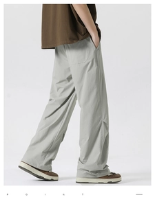 Detail of light gray wide-leg trousers showing back pocket design and twill texture