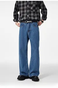 Detail of baggy light blue denim jeans for men with black leather belt and silver buckle