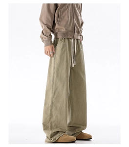 Detail view of khaki cotton cargo pants featuring a drawstring waist and decorative side seams