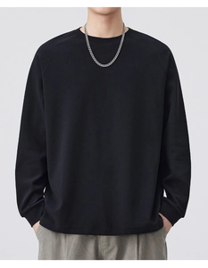 Detail of loose fit black crewneck sweatshirt with dropped shoulders and silver chain
