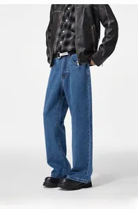 Close-up of baggy mid-blue denim trousers with a wide leg fit and washed texture
