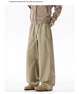 Detail of khaki cotton wide-leg trousers showing waist drawstring and stitching