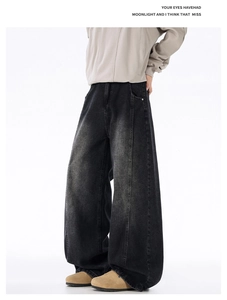 Close-up of vintage washed black wide-leg denim jeans with vertical stitching details